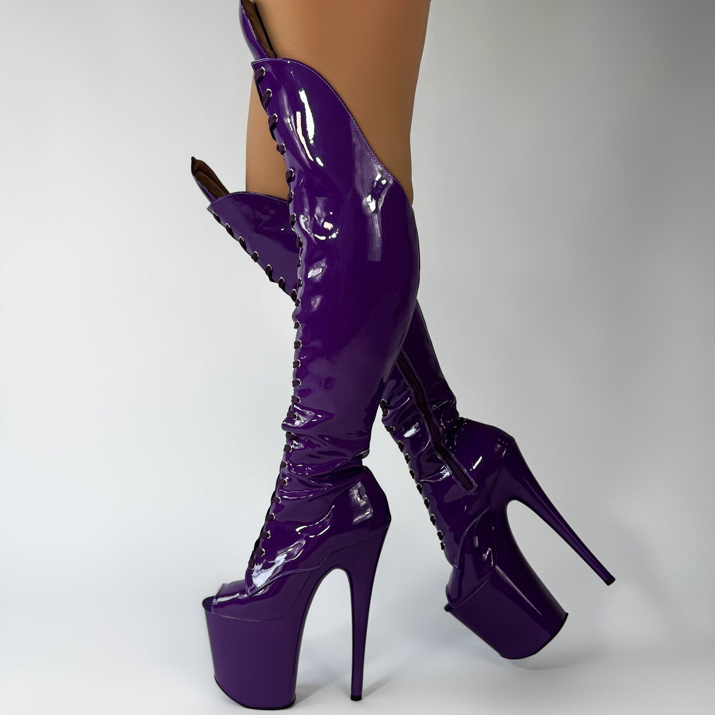 Purple high-heeled platform boots on a white background